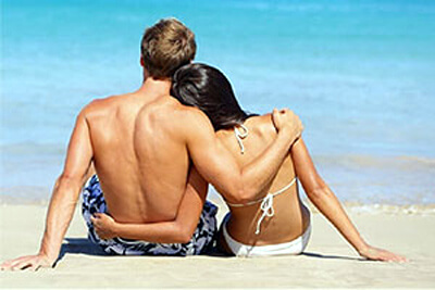 par som sitter på stranden og ser på havet